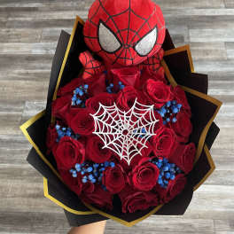 Spider-Man plush atop a bouquet of red roses with blue accents