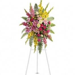 Tall floral spray with pink, yellow, and white flowers on a stand