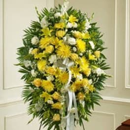 Standing spray of yellow and white flowers with ribbon on an easel