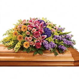 Colorful floral casket spray with pink, purple, and yellow blooms