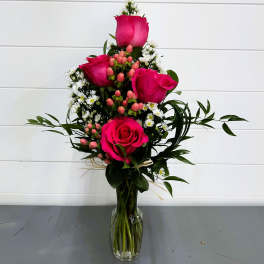 Pink roses and small white daisies in a clear glass vase