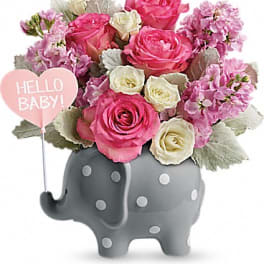 Pink and white roses in a gray elephant vase with a "Hello Baby!" sign