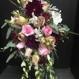 Bouquet of pink and beige roses with dark purple blooms