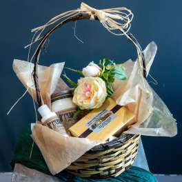 Gift basket with a flower, candle, lotion, and candy box