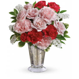 Pink and red carnation arrangement with white filler flowers in a silver glass vase