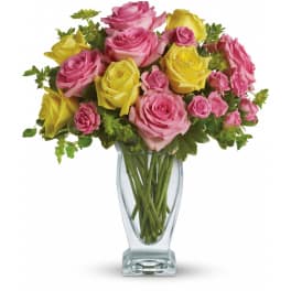 Bouquet of pink and yellow roses arranged in a clear glass vase
