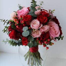 Bouquet of red and pink roses in a clear glass vase