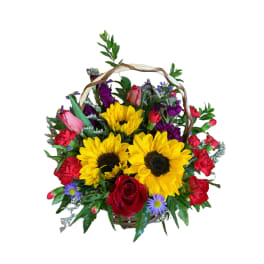 Basket arrangement with sunflowers, roses, carnations, and purple daisies