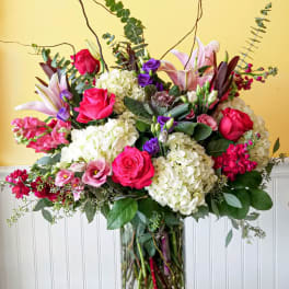 Large mixed bouquet of pink, white, and purple flowers in a glass vase