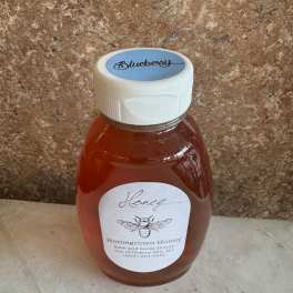 A plastic bottle of blueberry honey with a white cap