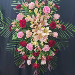 Standing floral spray with roses and lilies on an easel