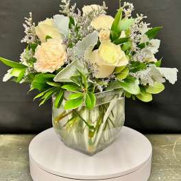 Cream and peach floral arrangement in a clear glass vase