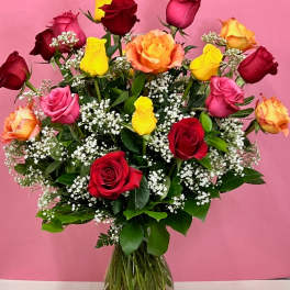 Mixed roses in a clear glass vase with baby's breath