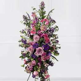 Tall standing spray of pink and purple flowers on a white background