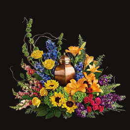 Colorful floral arrangement around a copper urn on a black background