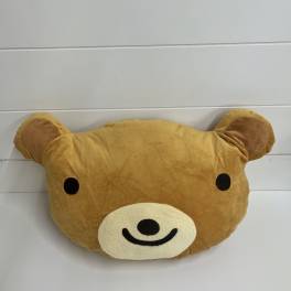 Brown teddy bear face plush pillow with black eyes and a smiling muzzle