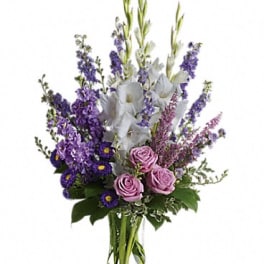 Purple and pink floral arrangement in a clear glass vase