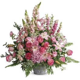 Tall pink arrangement with lilies, roses, and snapdragons in a gray ceramic urn