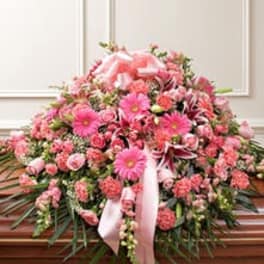 Large pink floral casket spray with ribbon accents