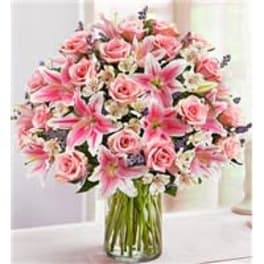 Pink roses and lilies in a clear glass vase