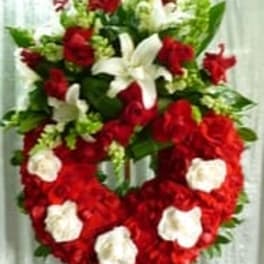 Heart-shaped red and white floral standing spray on an easel