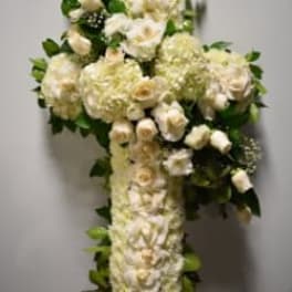 White floral arrangement shaped like a cross