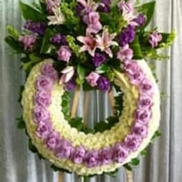 Standing floral wreath with pink and purple flowers on an easel
