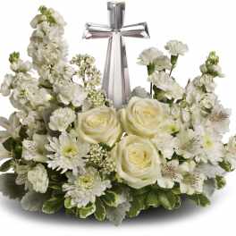 White floral arrangement with a silver cross centerpiece