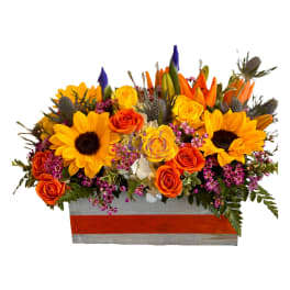 Bright mixed bouquet with sunflowers and orange roses in a rectangular box