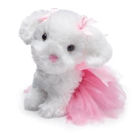 White plush puppy wearing a pink tulle dress and bow
