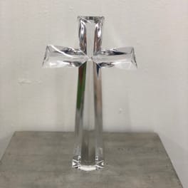 Clear glass cross standing on a surface