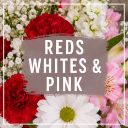 Bouquet of red, white, and pink flowers with a white daisy in front