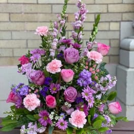 Basket arrangement of pink and purple flowers with tall spikes