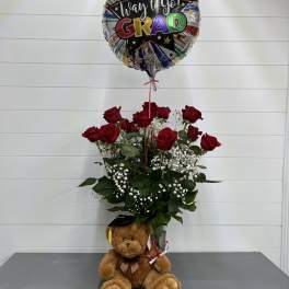 Red rose arrangement with a graduation balloon and teddy bear