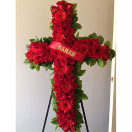 Red floral cross on an easel with a ribbon reading MAMAN