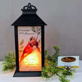 Black lantern with a memorial card and faux greenery sprigs