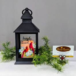 Black lantern with a "Simply Blessed" card and faux greenery.