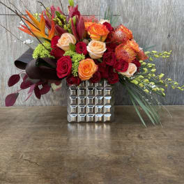 Mixed bouquet of red and orange roses in a silver vase