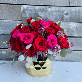 Bouquet of red and hot pink roses in a gold vase