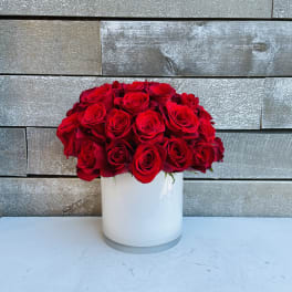 Red rose bouquet in a white cylindrical vase