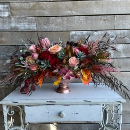 Large mixed floral arrangement in a copper vase
