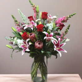 Mixed bouquet of red roses and pink lilies in a glass vase