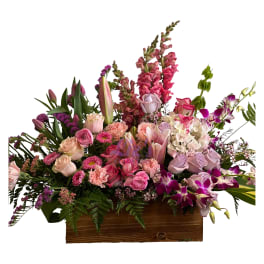 Mixed pink and lavender floral arrangement in a wooden box