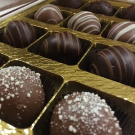 Box of assorted chocolate truffles in gold tray