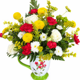 Bouquet of red, white, and yellow flowers in a white mug vase