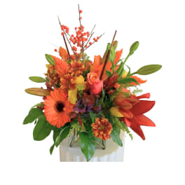Orange and red mixed bouquet in a clear vase