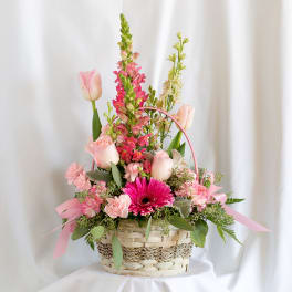 Pink floral basket arrangement with tulips, gerbera daisy, and snapdragons
