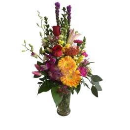 Tall mixed bouquet in a glass vase with red roses and yellow daisies