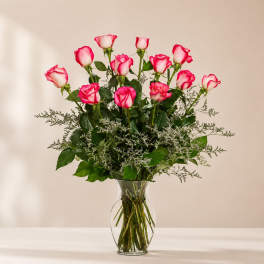Pink and white roses arranged in a clear glass vase