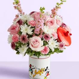 Pink and white flower arrangement in a Mickey Mouse tin with a red heart topper